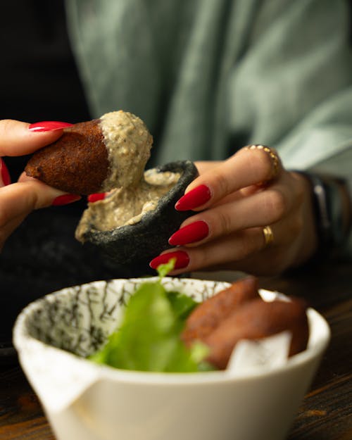 A woman is eating a food with her hands