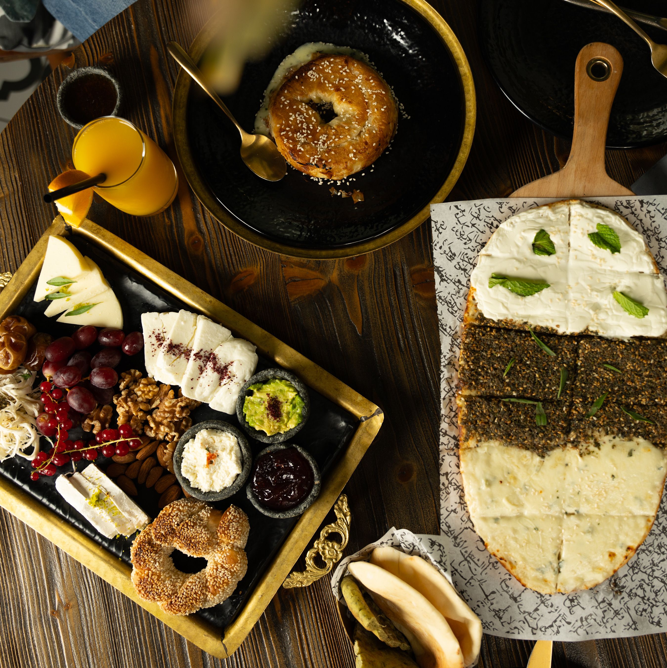 A vibrant and diverse Turkish breakfast spread featuring pide, simit, and fresh fruits.