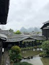 以山为背景的花园池塘，映衬着传统亚洲建筑的风景