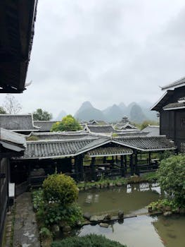 以山为背景的花园池塘，映衬着传统亚洲建筑的风景