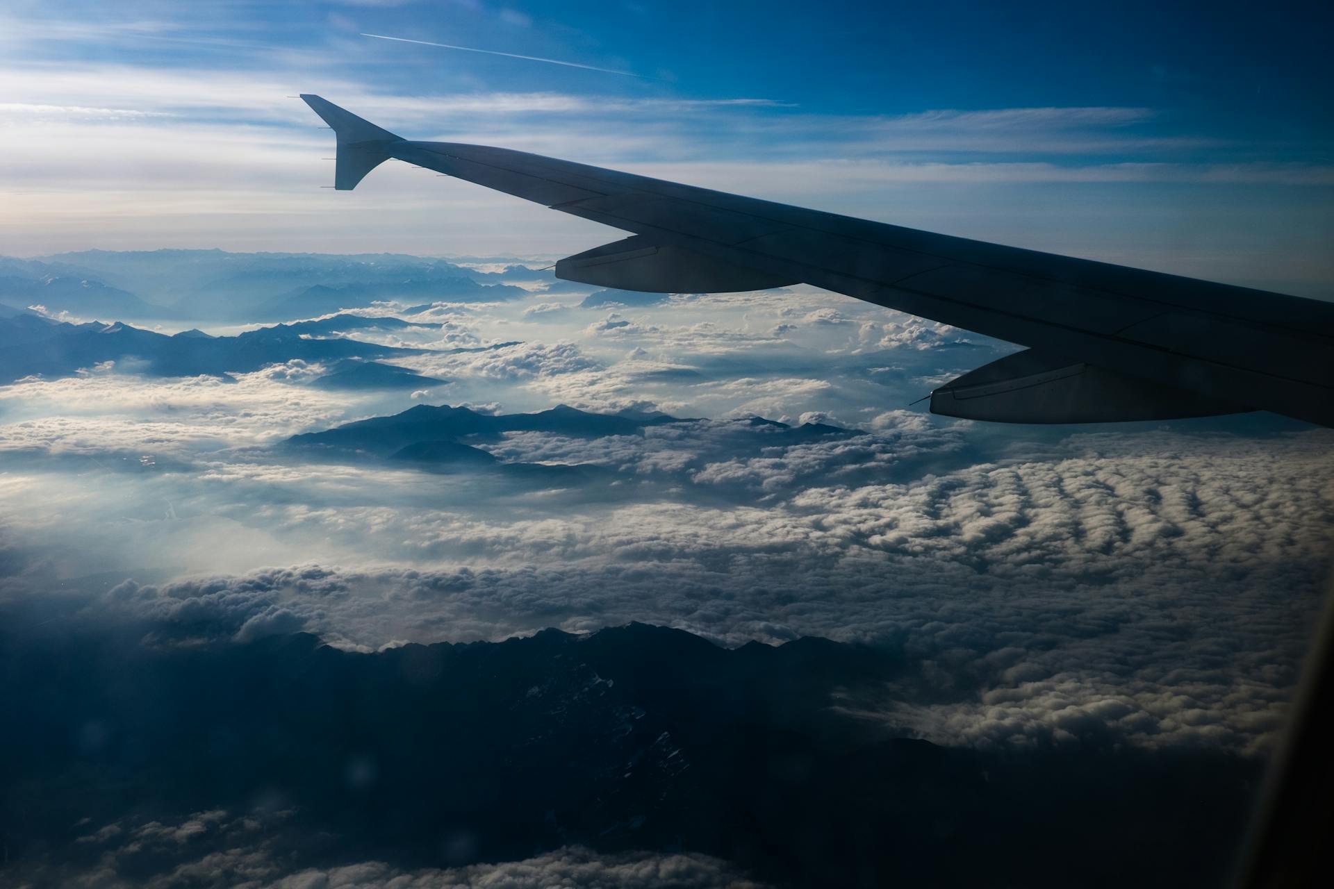 Stunning view of the Swiss Alps and clouds from an airplane window. Perfect for travel enthusiasts.