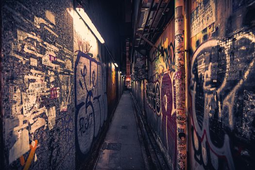 A moody, graffiti-covered alleyway in Hong Kong with vibrant street art and urban textures.
