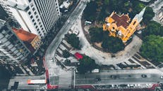 从空中俯瞰繁忙的城市十字路口，可以看到一座黄色教堂和来往的车辆