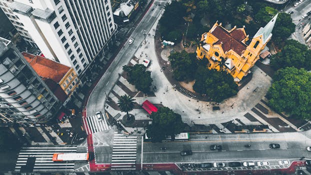 从空中俯瞰繁忙的城市十字路口，可以看到一座黄色教堂和来往的车辆