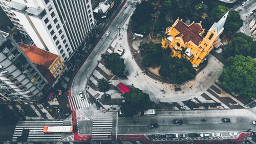 Free Top view of a bustling city intersection with a yellow church and traffic. Stock Photo