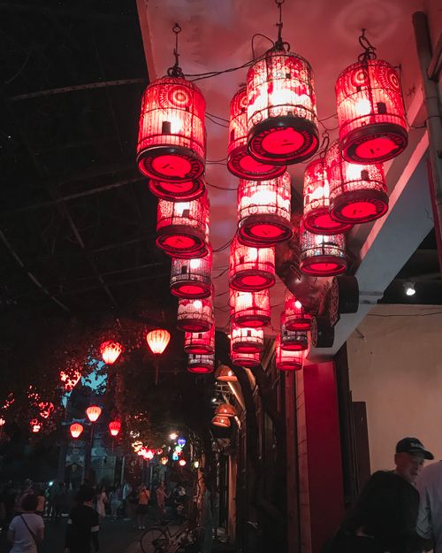 Free Red paper lanterns create a warm ambiance on an Asian street at night, enhancing the cultural atmosphere. Stock Photo