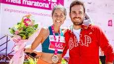 戴着奖牌和鲜花的马拉松冠军微笑着与朋友一起庆祝