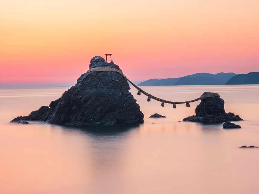 View of Meoto Iwa rocks at sunrise, showcasing a serene seascape and cultural landmarks.