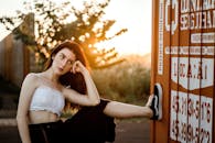 日落时分，一位年轻女子在容器旁若有所思地摆着姿势，神情随意而沉静