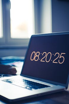 在办公环境中，笔记本电脑在桌面上显示数字时钟，营造出科技感十足的工作空间