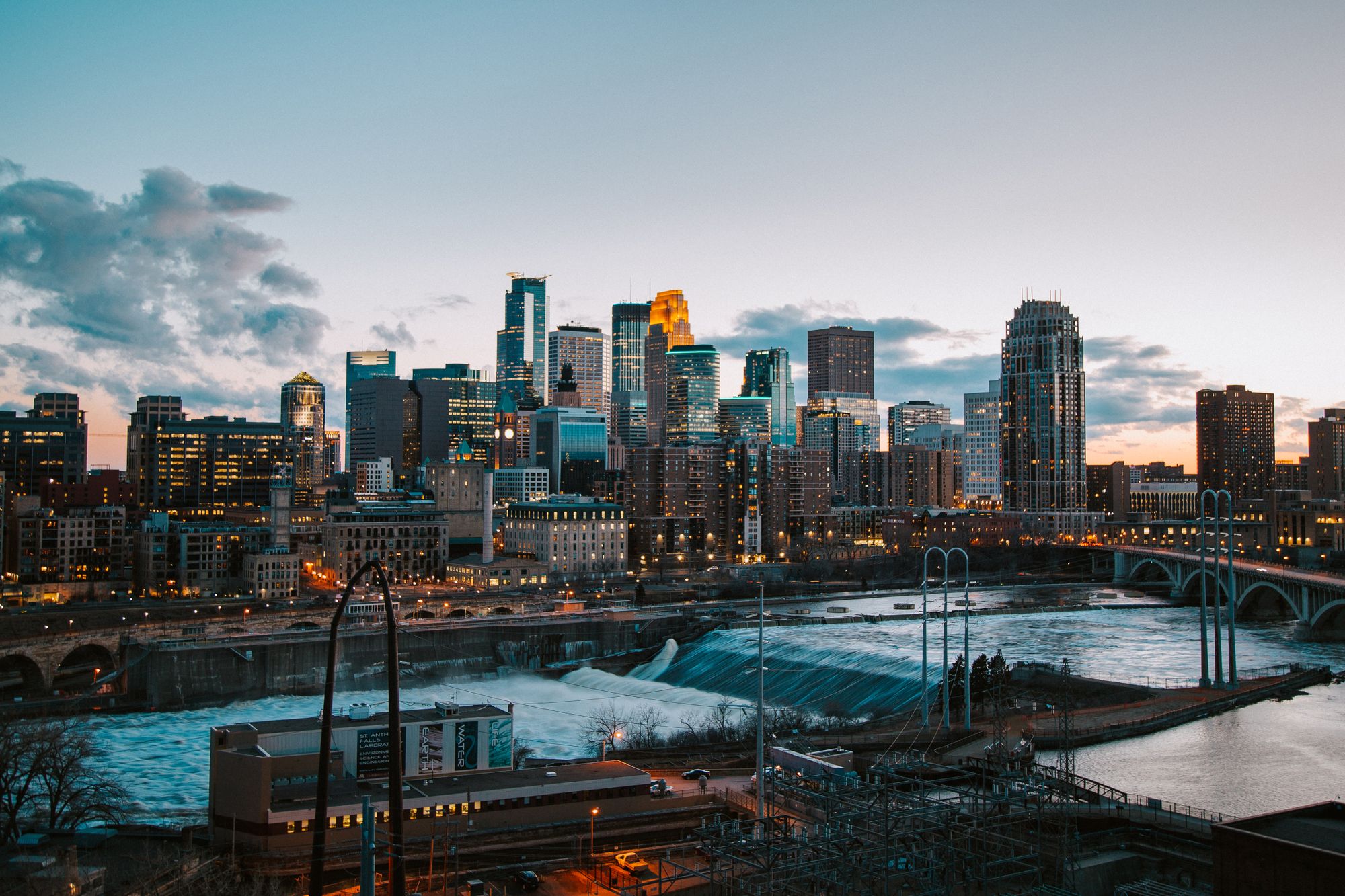 Minneapolis skyline with the Mississippi River and a bridge at sunset