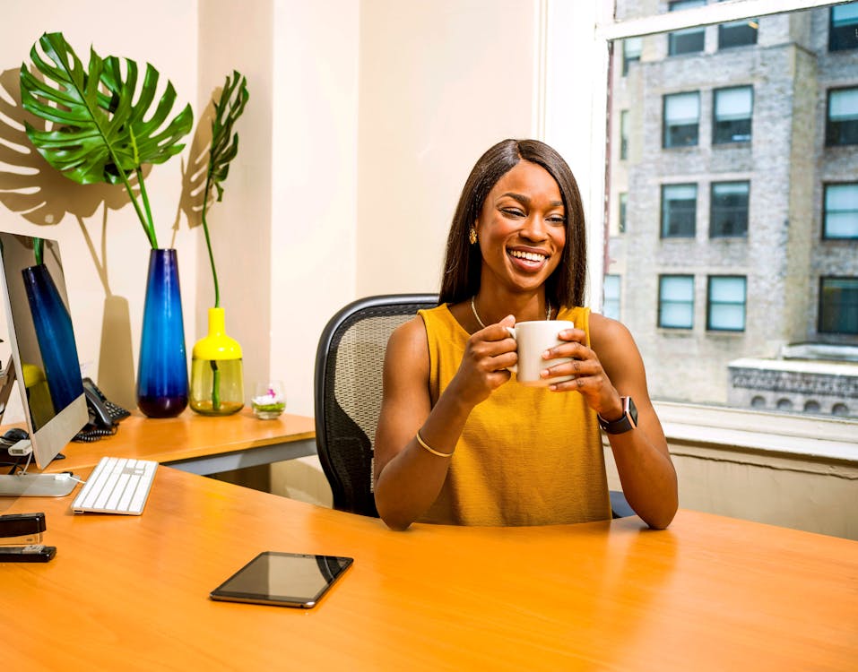 Free Woman Holding White Ceramic Mug At Desk Stock Photo