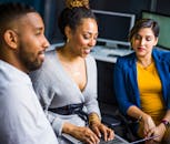 一群同事在现代化的办公环境中使用笔记本电脑协作完成一个项目