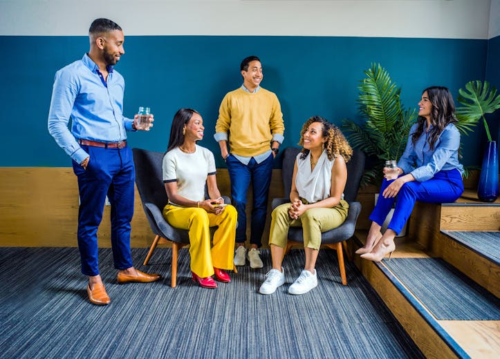 Diverse group of friends laughing and talking together outdoors