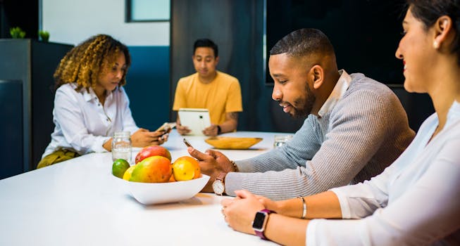 A diverse team of adults using technology while brainstorming in a contemporary office setting.