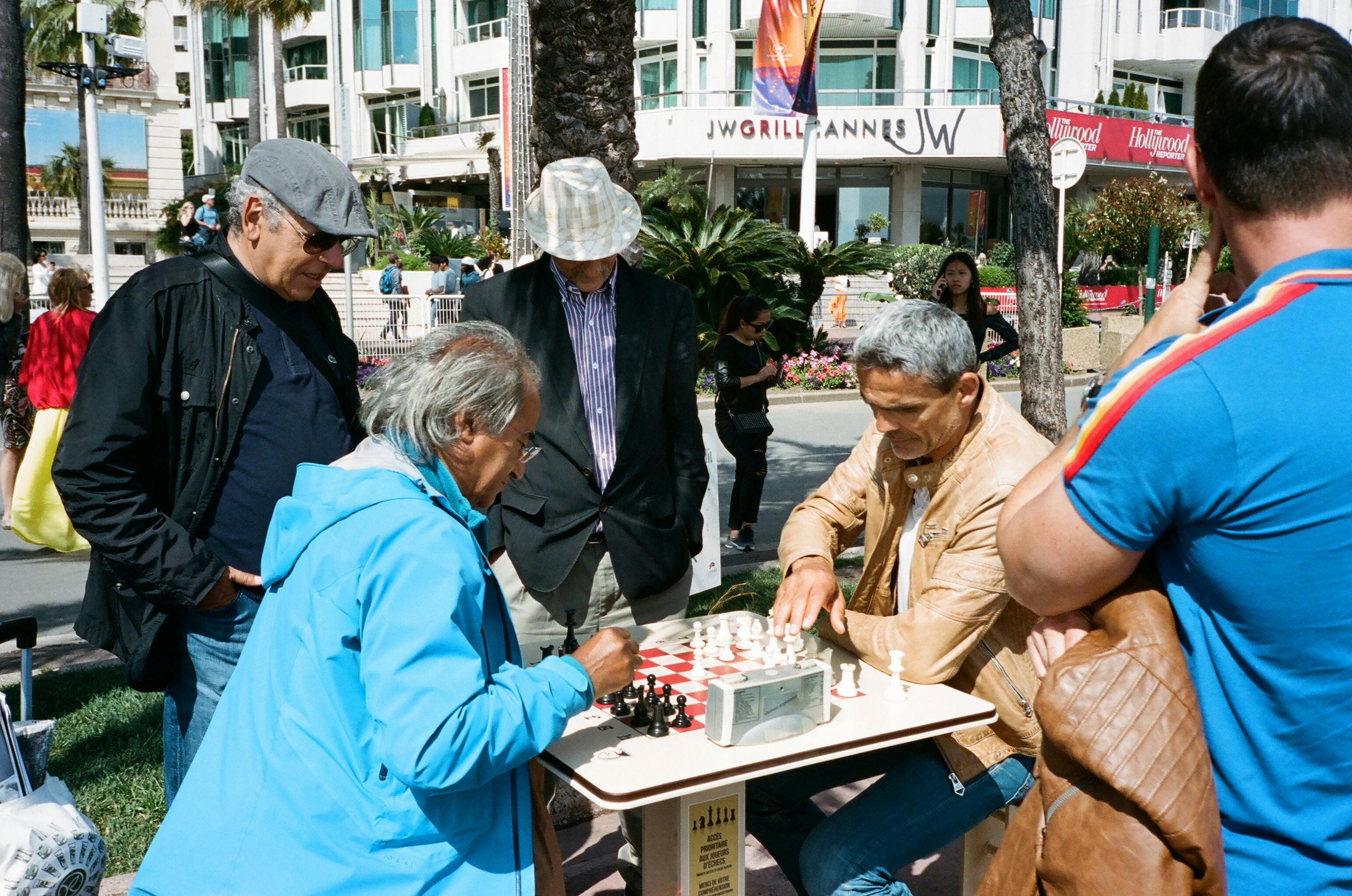 people watching two men playing chess