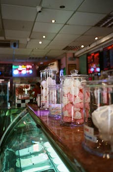 在冰淇淋店的柜台玻璃罐里，展示着五颜六色的糖果