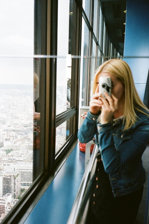 Photo of Woman Taking Picture of Glass Windows