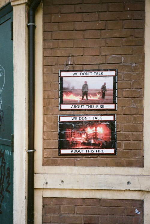 бесплатная Два плаката на кирпичной стене здания Стоковое фото
