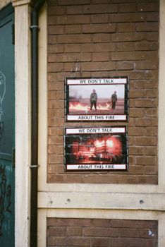 Interior of a rustic urban wall featuring thought-provoking fire posters.