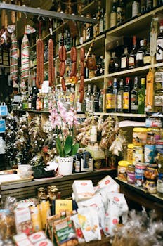 A vibrant indoor market stall displaying assorted sausages, bottles, and food products.