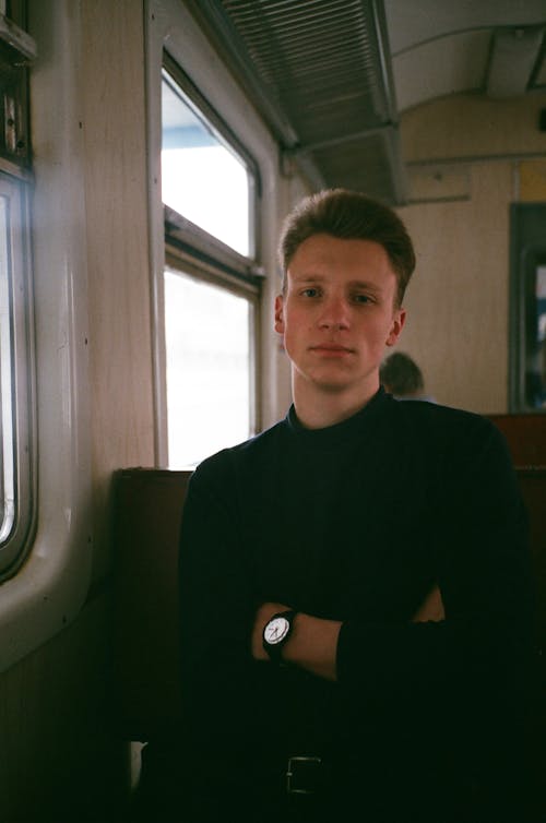 Photo of Man Sitting on the Train With His Arms Crossed