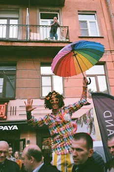 街头节日期间，充满活力的游行表演者高兴地挥舞着彩虹伞