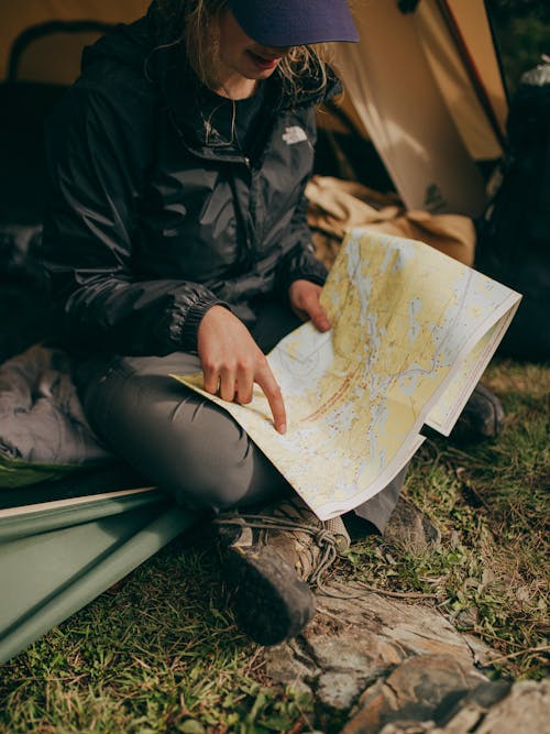 Foto Di Donna Seduta Mentre Indica Sulla Mappa Del Mondo