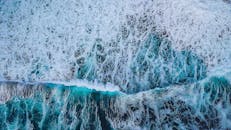 迷人的鸟瞰图中，蓝色海浪汹涌澎湃，展现了大自然的混乱与美丽