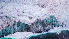 航拍动态捕捉绿松石海浪撞击海岸的景象