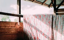 乡村屋顶下的木头上挂着有图案的布，阳光透过