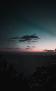 A tranquil twilight scene capturing silhouetted trees against a colorful sky, evoking serenity and calm.