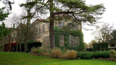 英国一座经典的庄园，常春藤覆盖，四周环绕着郁郁葱葱的绿色植物