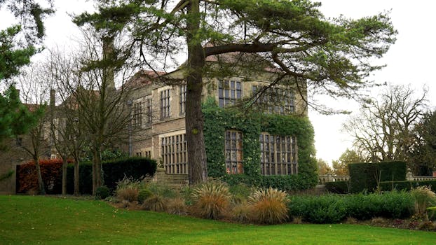 英国一座经典的庄园，常春藤覆盖，四周环绕着郁郁葱葱的绿色植物