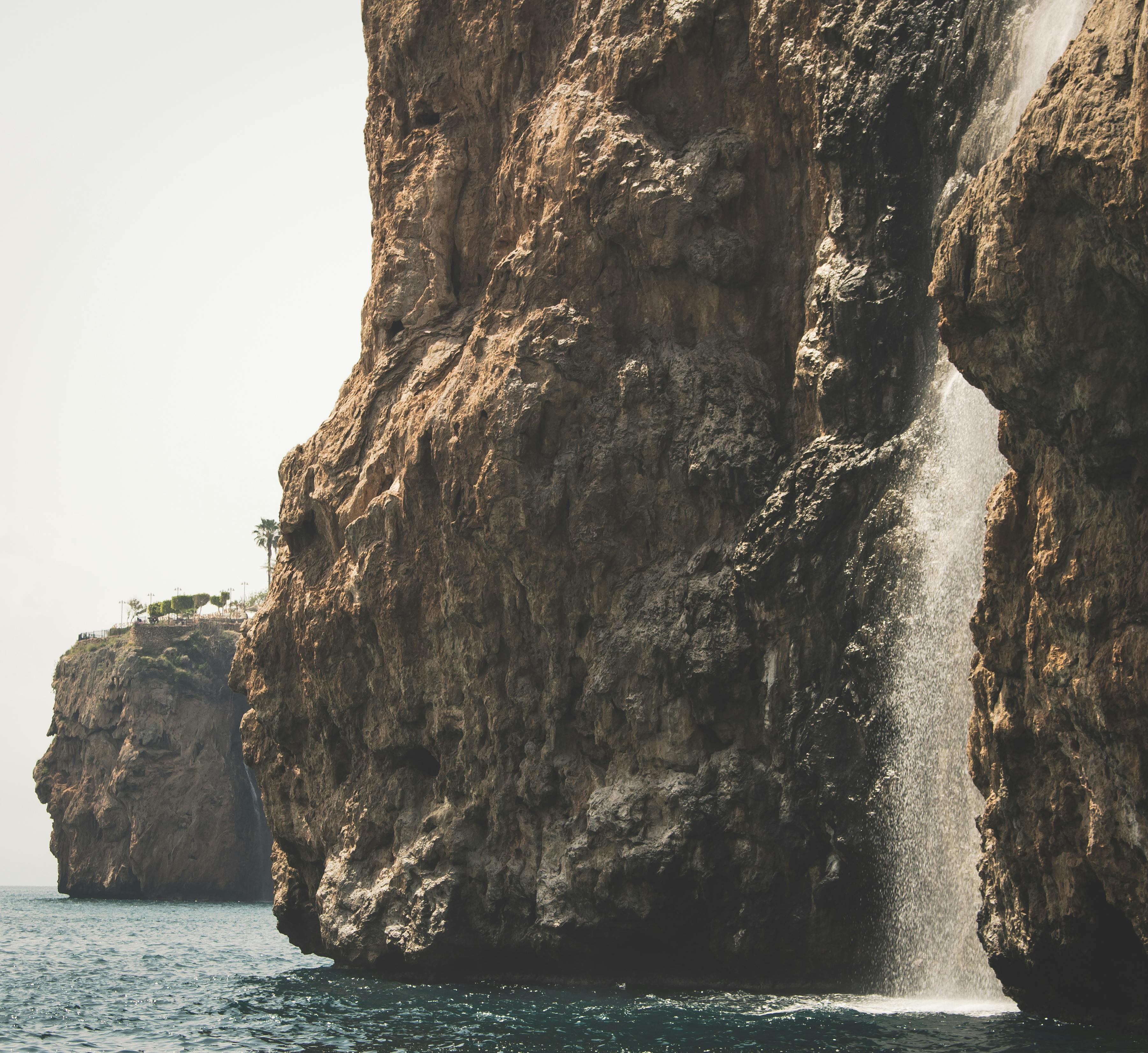 一道令人惊叹的瀑布从崎岖的悬崖倾泻而下，汇入大海，尽显大自然的力量