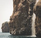 一道令人惊叹的瀑布从崎岖的悬崖倾泻而下，汇入大海，尽显大自然的力量