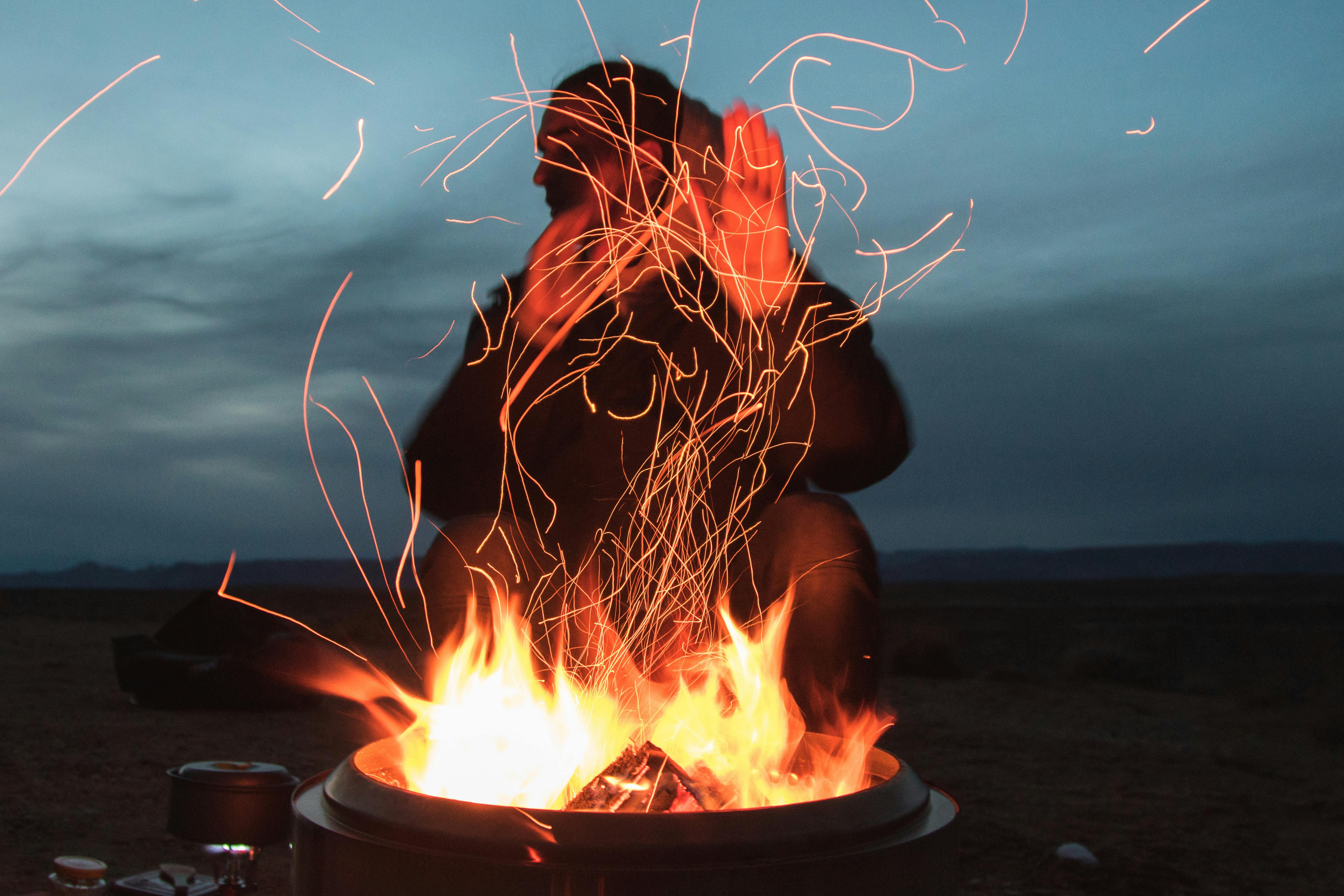 Man Sitting Facing Fire In Pot During Night Free Stock Photo
