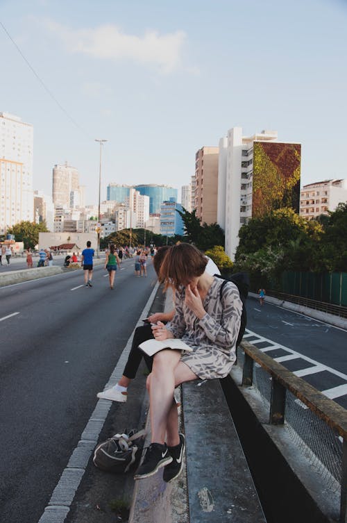 Mujer Sentada Sobre Barandillas Bajo Nubes Grises