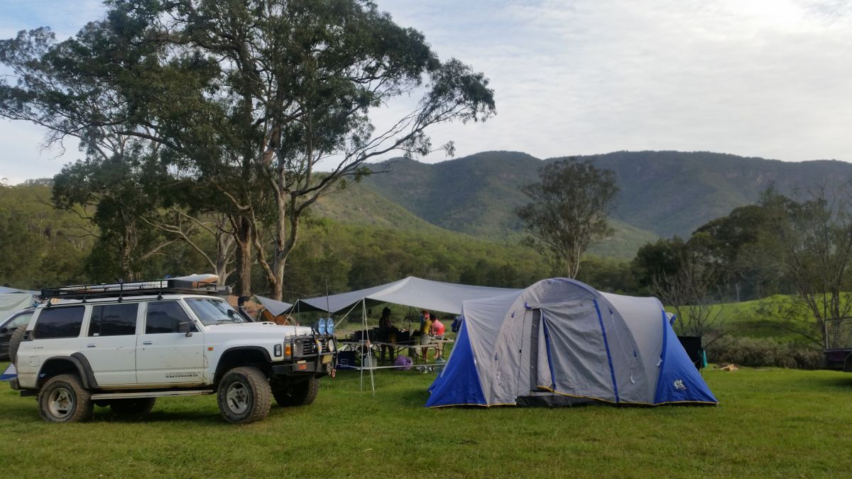 Campsite setup in the wilderness with tent and vehicle