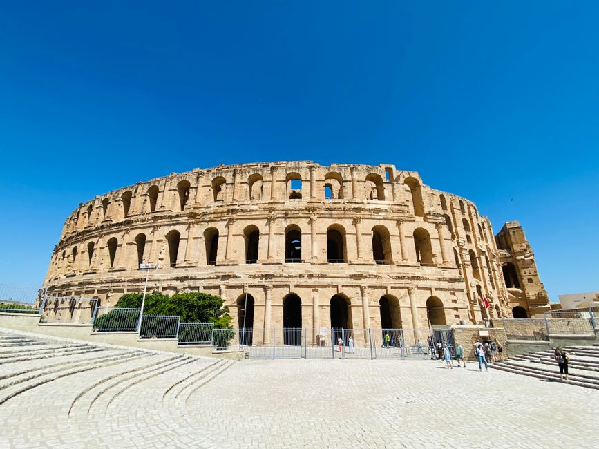 Historic Roman amphitheatre in El Djem, Tunisia, under a clear blue sky.