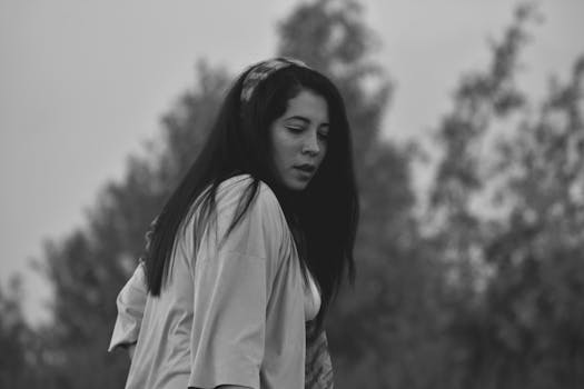 一位年轻女子在户外拍摄的单色肖像，捕捉到了她深思的表情