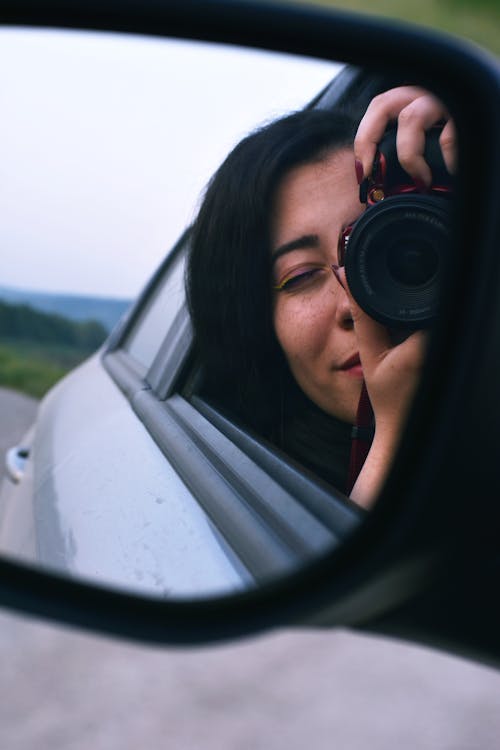 Woman Taking Picture On Vehicle Mirror