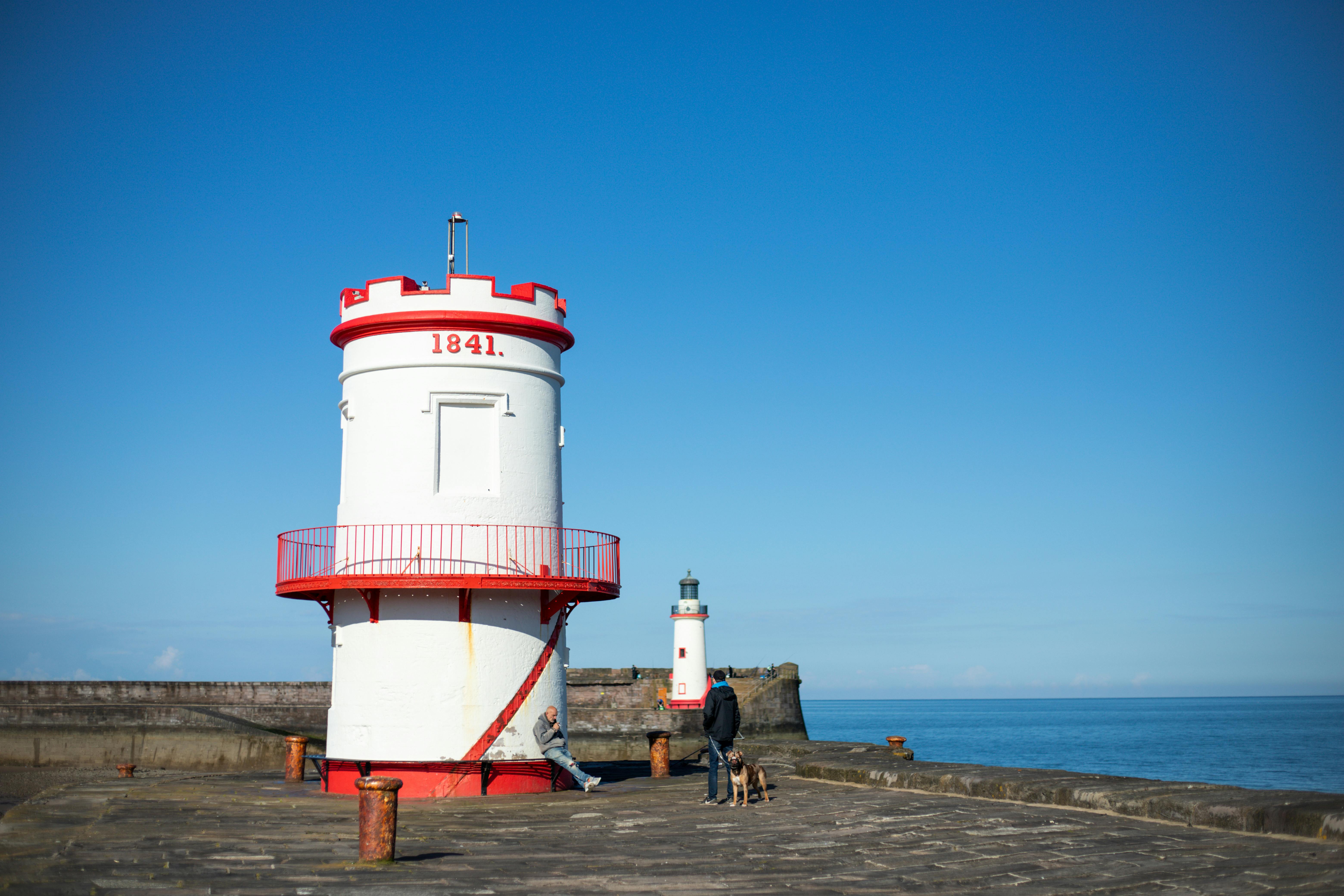 A beautifully captured view of Whitehaven Lighthouse with a clear blue sky, illustrating coastal charm and maritime history.