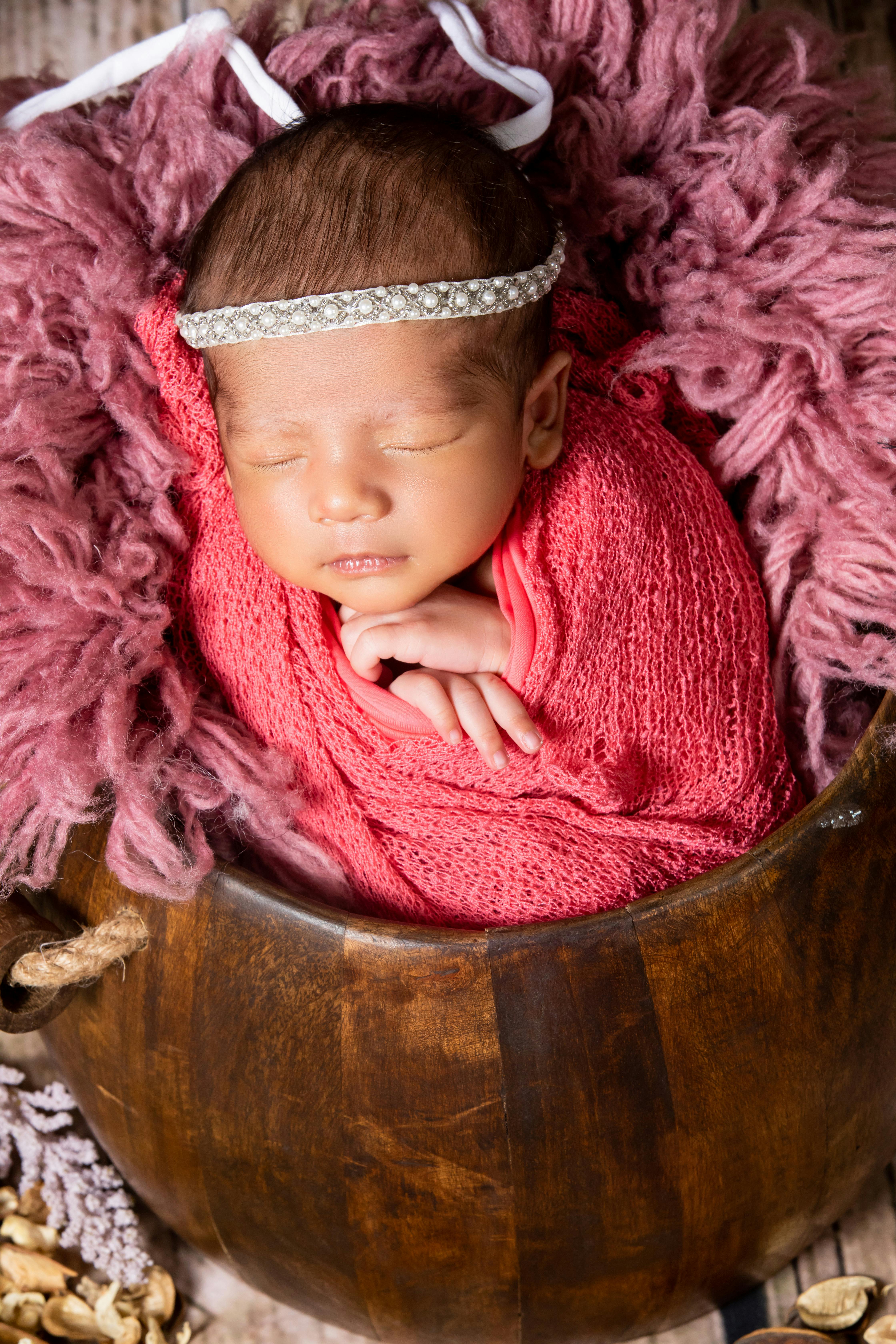 a newborn baby girl wrapped in a pink blanket