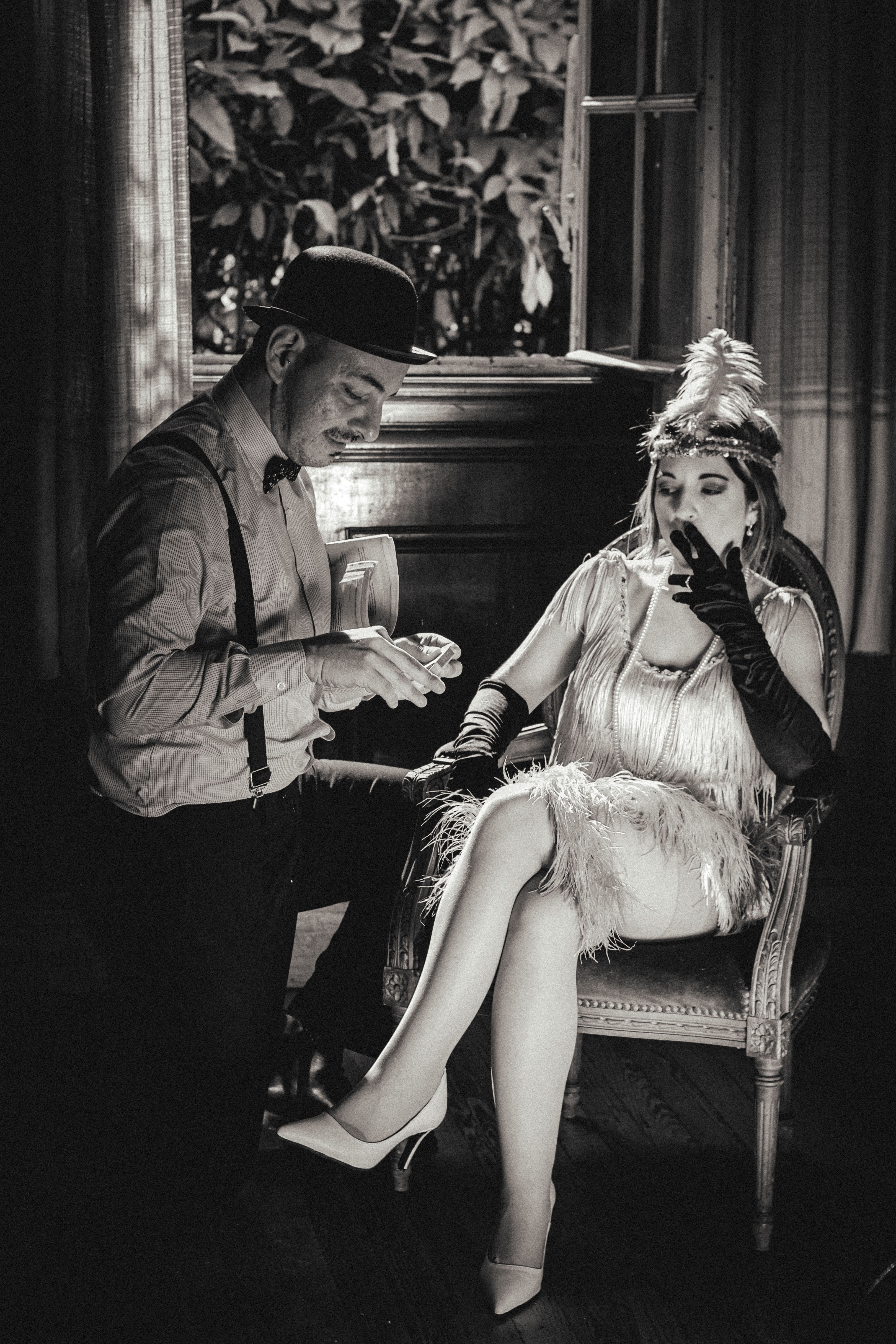 man-kneeling-before-woman-in-flapper-dress-sitting-and-smoking-free