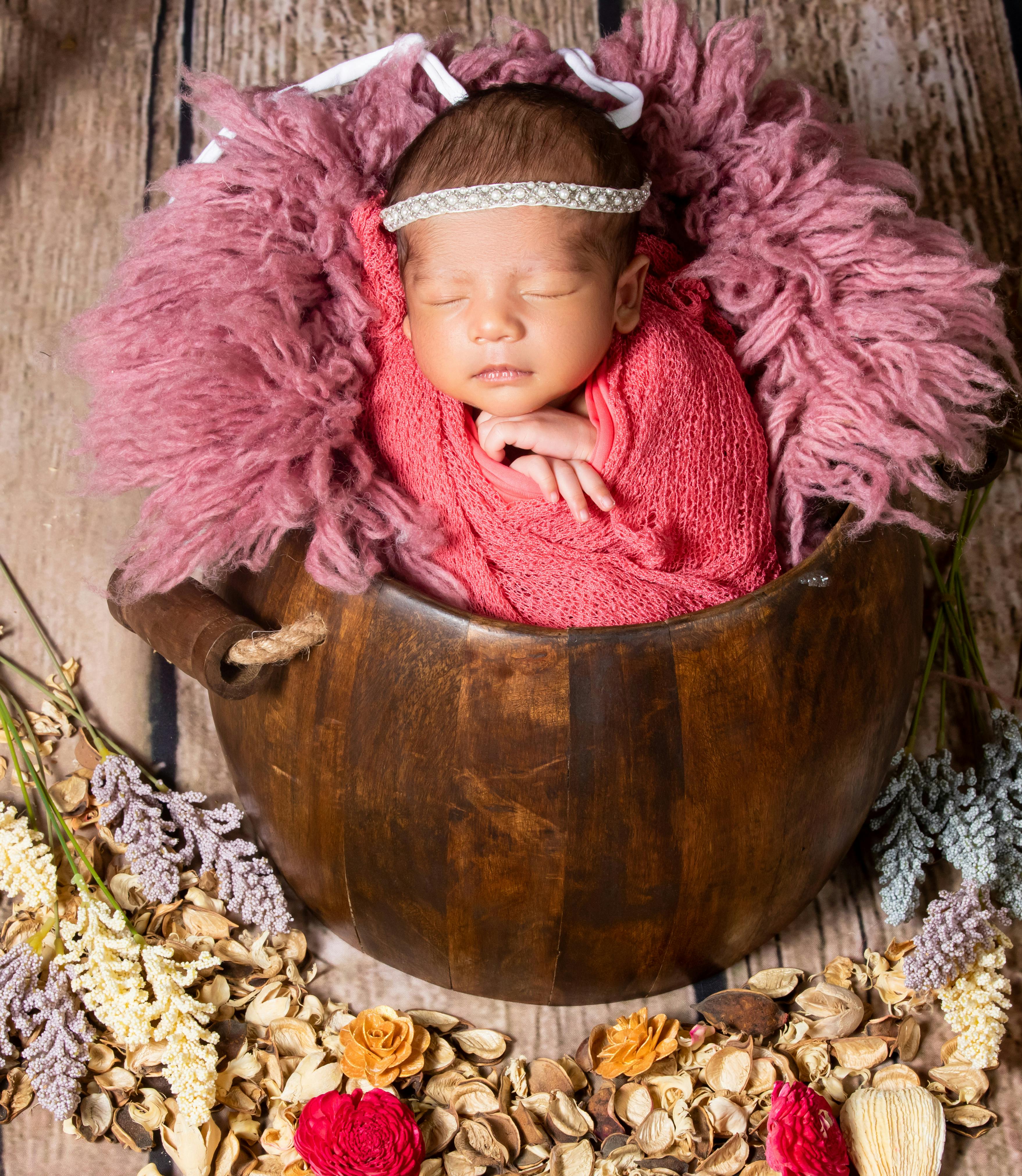 a newborn baby girl wrapped in a pink blanket