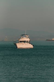 A luxurious motor yacht sails calmly on serene ocean waters, perfect for a peaceful getaway.