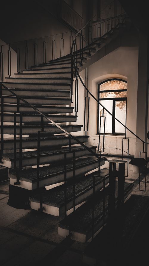 Free A vintage-style interior featuring an elegant, curved staircase with stylish handrails. Stock Photo