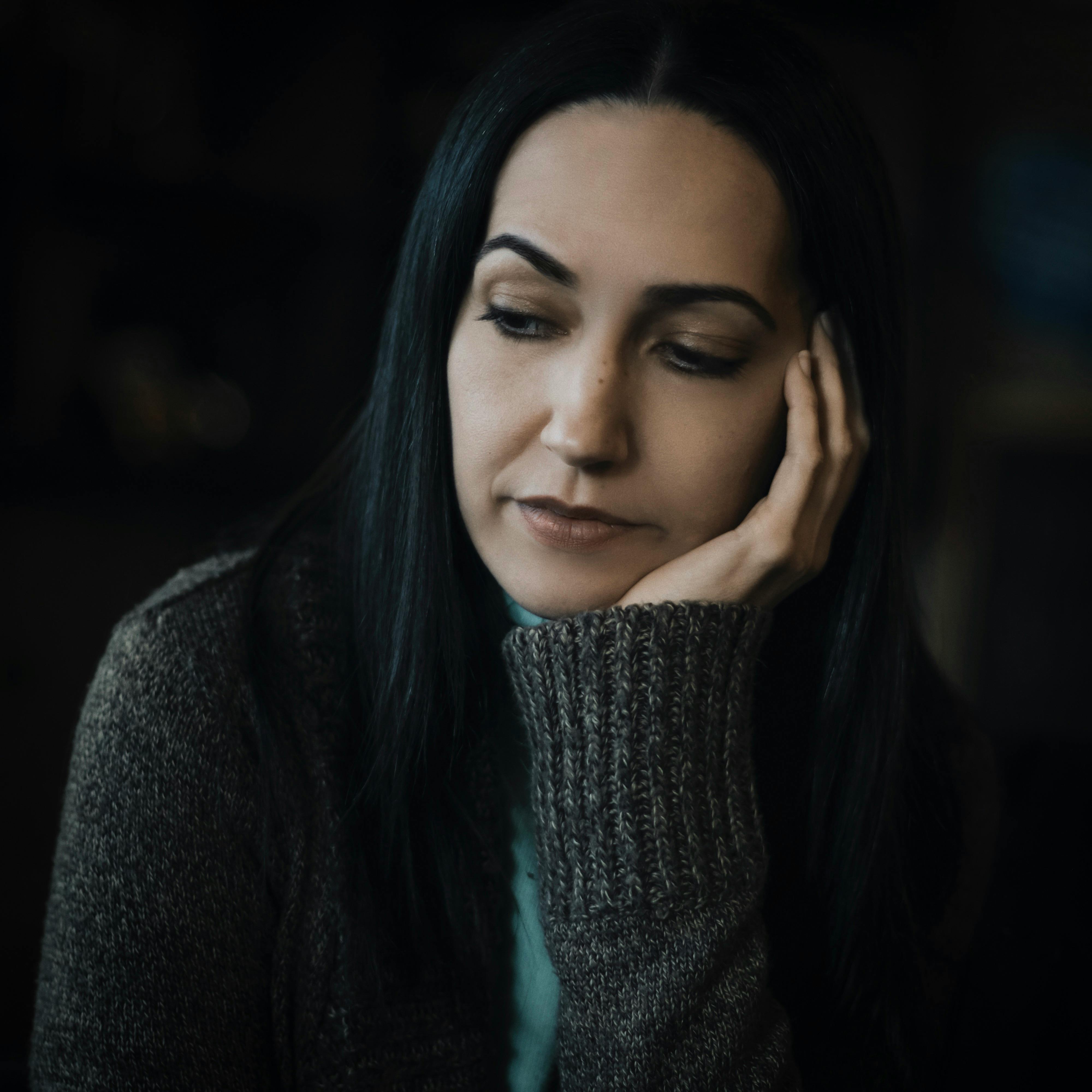 Frau trägt grauen Pullover und sieht traurig aus. | Quelle: Pexels