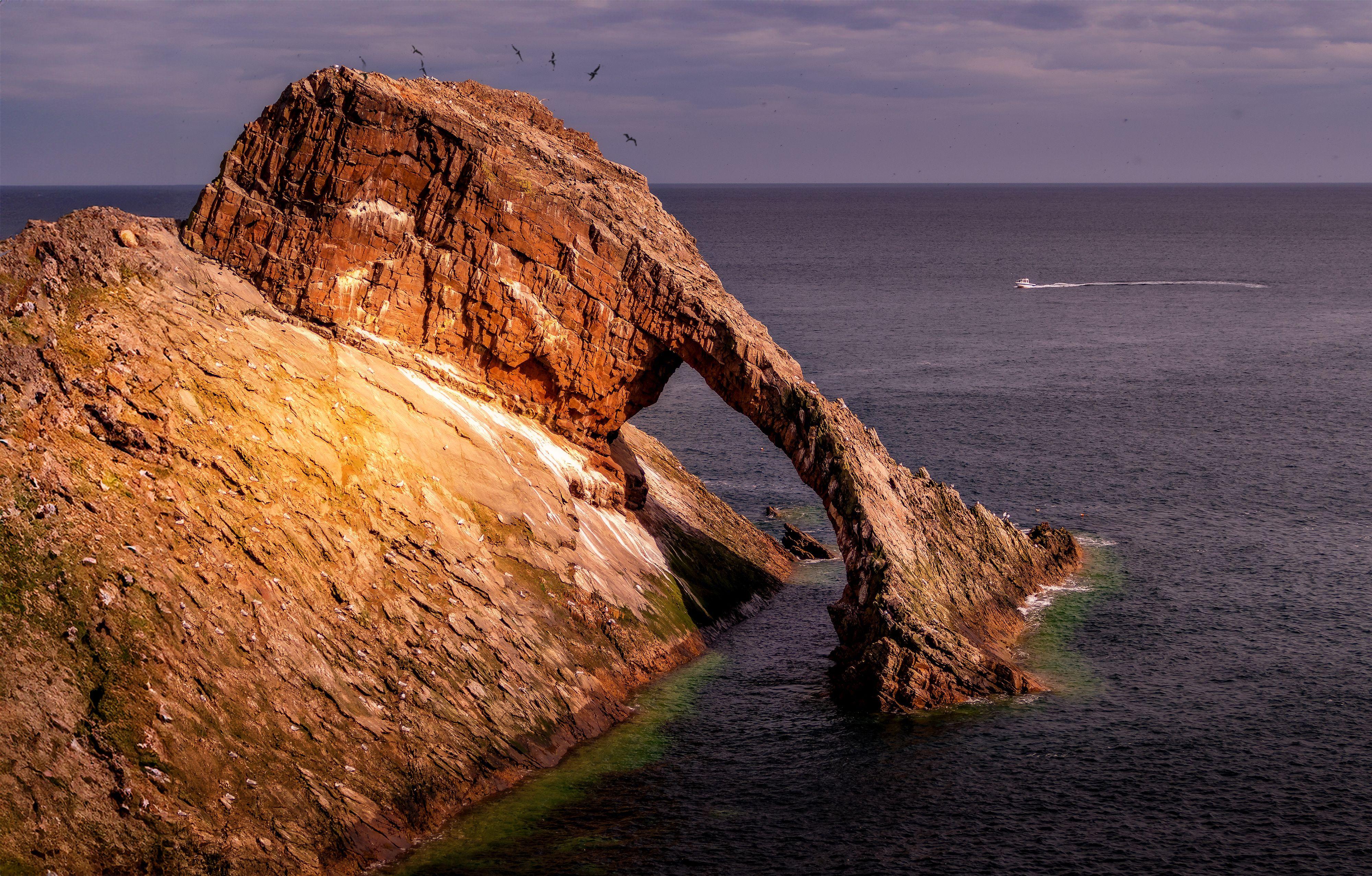 Scenic view of Bow Fiddle Rock, a striking sea arch formation in Portknockie, Scotland.
